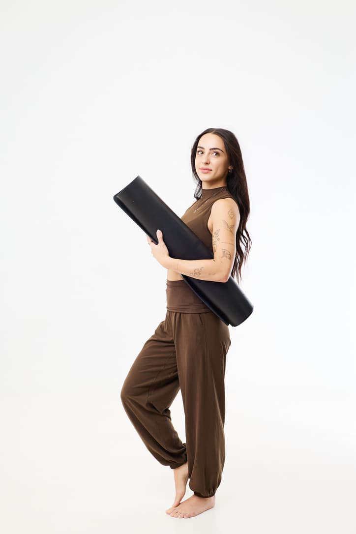 Lauren standing with her rolled yoga mat
