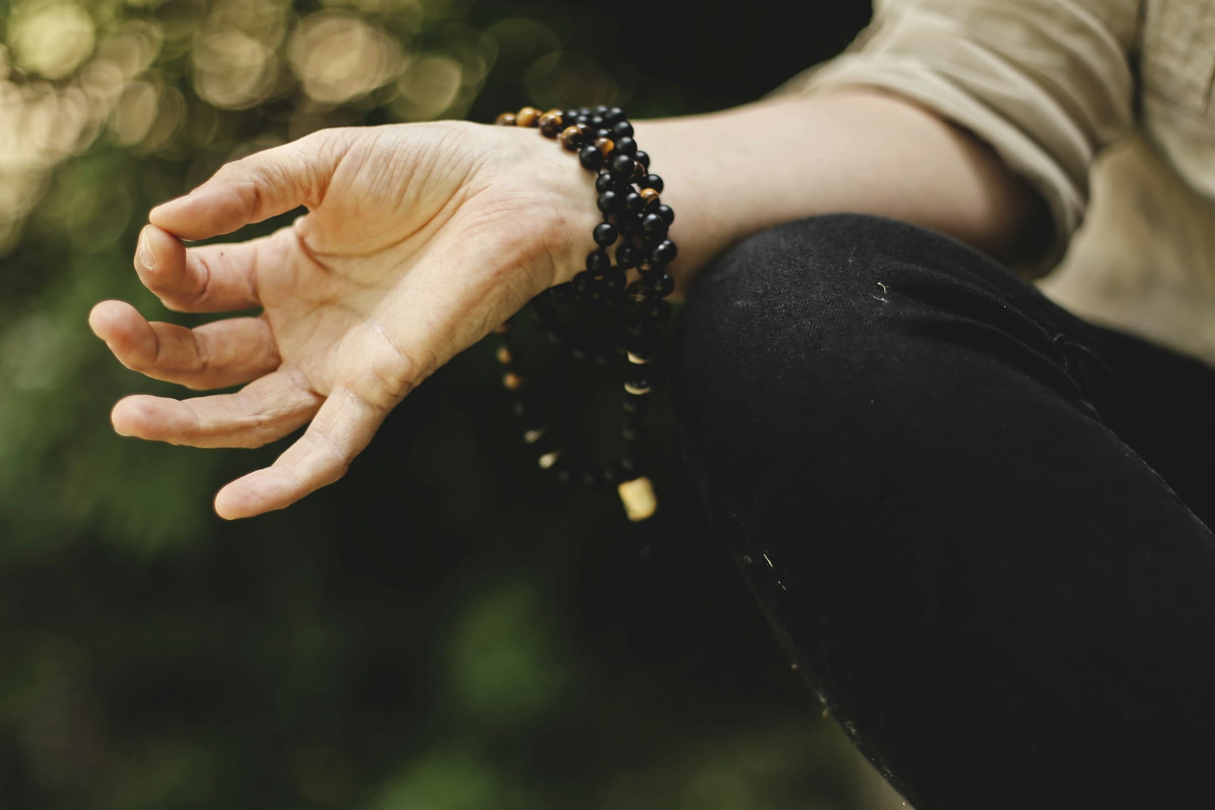 A hand resting in a meditation gesture outdoors